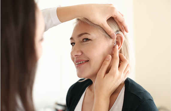 Hearing Aid Insurance woman trying hearing aid